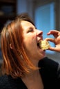 Redhead mature woman biting a peace of tasty cream cake Royalty Free Stock Photo