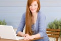 Portrait redhead woman with laptop on terrace