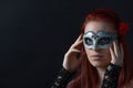 Portrait of redhead young woman holding carnival mask on her face Royalty Free Stock Photo