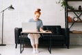 Portrait of redhead young woman student noting into the workbook important information from book Royalty Free Stock Photo