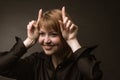 Portrait redheaded girl makes horns with hands