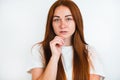 Portrait of redheaded young woman looking natural holding hand near her face on white backgroung, style and beauty