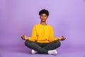 Portrait of relaxed african american boy sitting in lotus pose a
