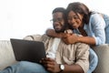 African american couple sitting on sofa, using digital tablet Royalty Free Stock Photo