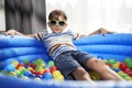 Portrait of relaxed boy in an inflatable ball pool