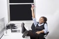 Relaxed businesswoman throwing paper airplane in office Royalty Free Stock Photo