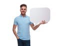 Portrait of relaxed man wearing polo shirt holding speech bubble