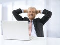 Portrait of relaxed senior businessman sitting in office.