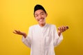 Portrait of relaxed smile young Asian Muslim man stay calm down holding a mobile phone