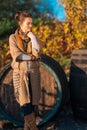 Portrait of relaxed woman winemaker standing in autumn vineyard