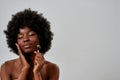 Portrait of relaxed young african american woman with perfect glowing skin massaging her face with jade roller, posing Royalty Free Stock Photo