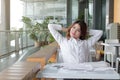 Portrait of relaxed young Asian business woman looking at far away in office. Royalty Free Stock Photo