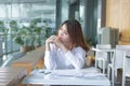 Portrait of relaxed young Asian employee looking at far away in office. Royalty Free Stock Photo