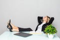 Portrait of a relaxed young businesswoman sitting with legs on desk in a office Royalty Free Stock Photo