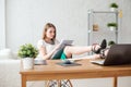 Portrait of a relaxed young businesswoman sitting with legs on desk in office. Royalty Free Stock Photo