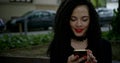 Portrait of a relaxed young lady in an autumn Park reading a text message on her mobile phone. Beautiful young girl with Royalty Free Stock Photo