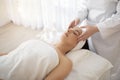 Portrait of relaxed young woman having facial massage in spa center Royalty Free Stock Photo