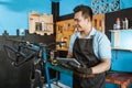 Portrait of a repairman in an apron as work clothes using a pad