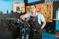 Portrait of a repairman in an apron leaning in a bicycle repair shop