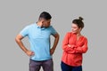 Portrait of resentful dissatisfied couple in casual wear standing together. isolated on gray background