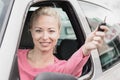 Portrait of responsible female driver holding car keys in her hand. Safe and responsible driving school and concept.