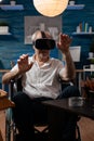 Portrait of retired artist living with disability using virtual reality goggles to visualize 3D model