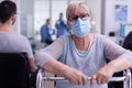 Portrait of retired disabled patient in hospital office looking at camera