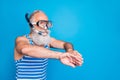 Portrait of retired pensioner swimming breaststroke with snorkel gear wearing striped costume  over blue Royalty Free Stock Photo