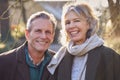 Portrait Of Retired Senior Couple Enjoying Winter Walk Through Village In Countryside Together