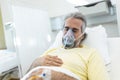 Portrait of retired senior man breathing slowly with oxygen mask during coronavirus covid-19 outbreak. Old sick man lying in Royalty Free Stock Photo