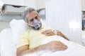 Portrait of retired senior man breathing slowly with oxygen mask during coronavirus covid-19 outbreak. Old sick man lying in Royalty Free Stock Photo