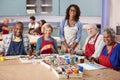 Portrait Of Retired Seniors Attending Art Class In Community Centre With Teacher