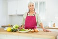 Mature woman cutting fresh vegetables for dinner Royalty Free Stock Photo