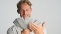 Portrait of rich bearded businessman looking happy showing wad of money on camera and smiling over white background