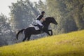 Rider man and black stallion horse galloping during eventing cross country competition Royalty Free Stock Photo
