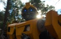 Portrait of a robot transformer Bumblebee standing among forest