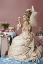 Portrait of rococo woman dressed as Marie Antoinette holding cake
