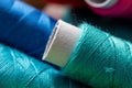 A portrait of a roll of colored thread lying on some other spools of yarn. The fiber is ready to be used for some sewing. The Royalty Free Stock Photo