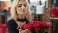 Portrait of romantic beautiful woman smiling and smelling roses feeling in love admiring luxury gift bouquet of roses Royalty Free Stock Photo