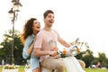 Portrait of man and woman riding on motorbike together through city street Royalty Free Stock Photo