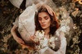 Portrait of a romantic girl, like a forest fairy, in a blooming garden with elements of phantasmagoria. The concept of Royalty Free Stock Photo