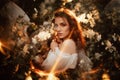 Portrait of a romantic girl, like a forest fairy, in a blooming garden with elements of phantasmagoria. The concept of Royalty Free Stock Photo