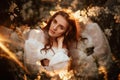 Portrait of a romantic girl, like a forest fairy, in a blooming garden with elements of phantasmagoria. The concept of Royalty Free Stock Photo