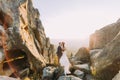 Portrait of romantic newlywed couple holding each other in sunset lights on majestic mountain landscape with big rocks Royalty Free Stock Photo