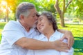 Portrait romantic older couple. Attractive handsome older husband embracing and kissing his older wife with love. Grandfather and Royalty Free Stock Photo