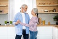 Portrait Of Romantic Senior Couple Dancing Together In Kitchen Interior Royalty Free Stock Photo
