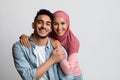 Portrait of romantic smiling muslim couple posing over grey studio background