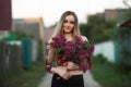 Portrait of a romantic smiling young woman with a bouquet of lilac outdoors shallow depth of field
