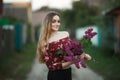 Portrait of a romantic smiling young woman with a bouquet of lilac outdoors shallow depth of field Royalty Free Stock Photo