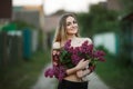 Portrait of a romantic smiling young woman with a bouquet of lilac outdoors shallow depth of field Royalty Free Stock Photo